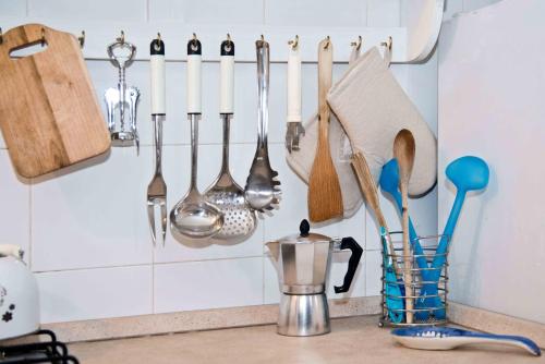 a kitchen counter with utensils hanging on a wall at Hopps Studio in Mazara del Vallo