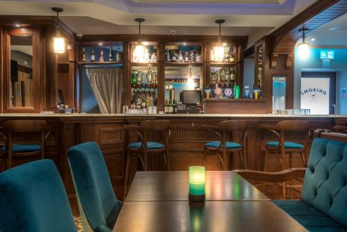a bar with a table with a candle on it at Shipquay Boutique Hotel in Derry Londonderry