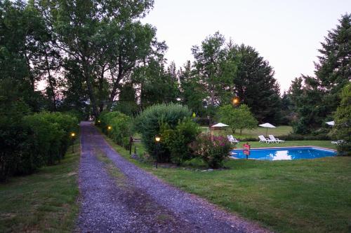 a gravel driveway leading to a pool in a garden at Cabañas Playa Linda in Pucón