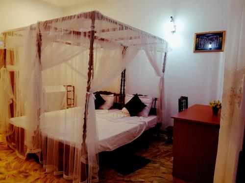 una camera da letto con un letto a baldacchino di South Heaven Villa a Hikkaduwa