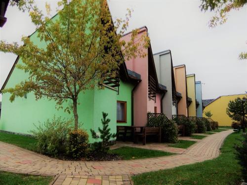 a row of buildings with a tree and a sidewalk at Tatralandia Apartmán in Liptovský Mikuláš