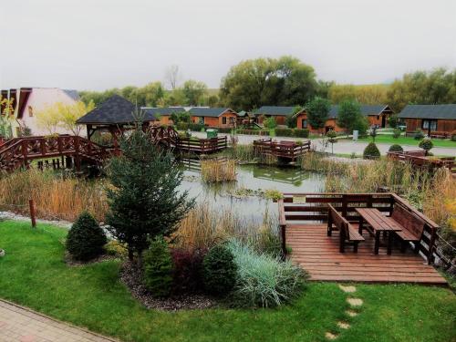 a park with wooden benches and a pond at Tatralandia Apartmán in Liptovský Mikuláš