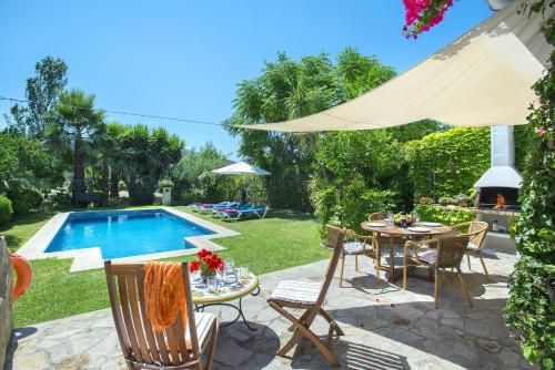 ポリェンサにあるOwl Booking Villa El Campet - Rustic Stayのスイミングプールのそばにパティオ(テーブル、椅子付)