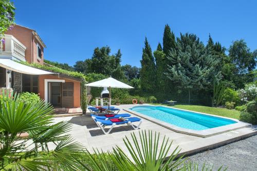 a backyard with a swimming pool and chairs and a house at Owl Booking Villa Bennasar - Rustic Stay in Pollença