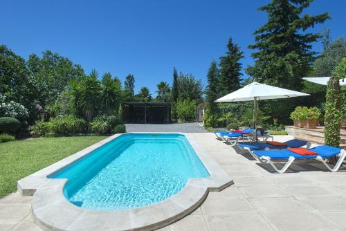 a swimming pool with chairs and an umbrella at Owl Booking Villa Bennasar - Rustic Stay in Pollença