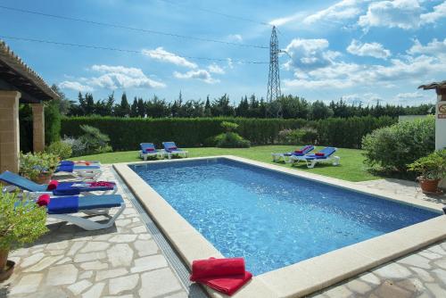 una piscina con tumbonas y sillas en un patio en Owl Booking Villa Maria - Family and Friends, en Port de Pollença (Puerto Pollensa)