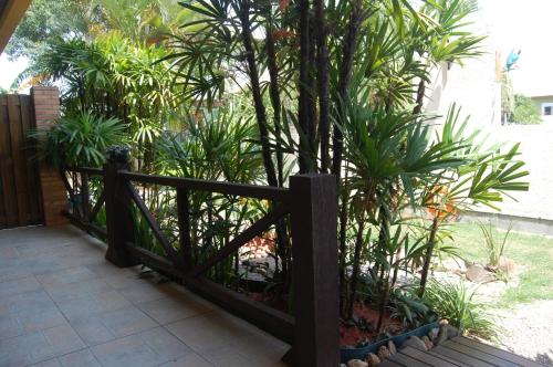 a wooden fence with a tree in a garden at Pousada Santa Genoveva campeche in Florianópolis