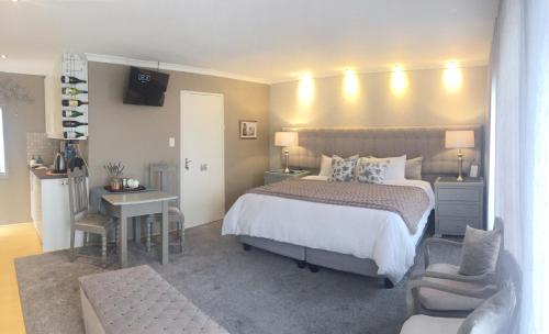 a bedroom with a bed and a desk and a chair at Se La Vie Guest Suite in Big Bay