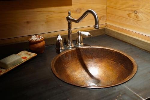 a sink in a bathroom with a wooden wall at Logden Lodge in Nelson