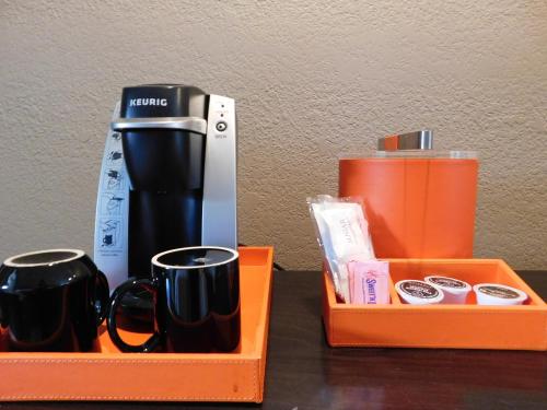 an orange tray with two cups and a coffee maker at Wave Street Inn in Monterey