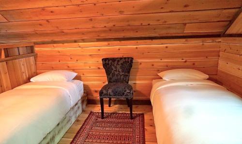 a room with two beds and a chair between them at Logden Lodge in Nelson
