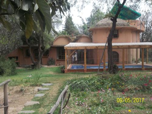 a house with a thatched roof in a garden at "Dulces Sueños" in Cochabamba