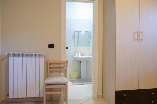ein Badezimmer mit einem Waschbecken, einer Dusche und einem Stuhl in der Unterkunft B&B Nola Domus in Cimitile