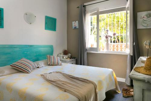 レスカラにあるCasa Llunaのベッドルーム1室(青いヘッドボード付きのベッド1台、窓付)