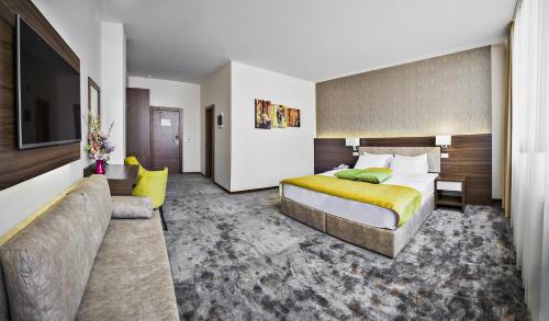 Hotel Marshal Garni في بلغراد: غرفه فندقيه بسرير واريكه