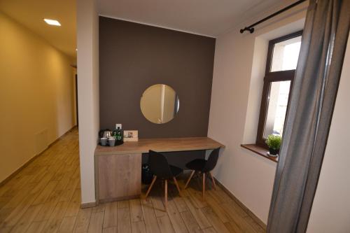 Zimmer mit einem Waschtisch mit einem Spiegel und 2 Stühlen in der Unterkunft SleepWell Apartments in Legnica