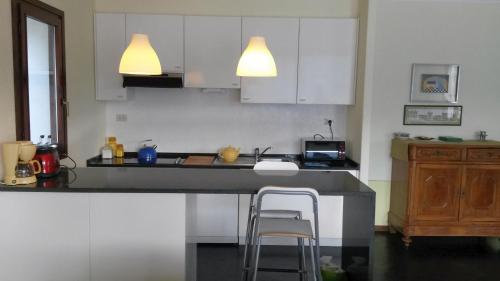 波爾托瓦爾特拉瓦利亞的住宿－Golfo Aranci，厨房配有白色橱柜和带2张凳子的台面