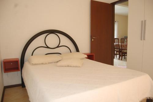 a bedroom with a large bed with white sheets at Pousada Santa Genoveva campeche in Florianópolis