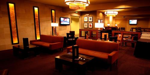 a lobby with couches and tables and a television at Mirabeau Park Hotel in Spokane Valley