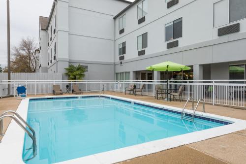 a swimming pool in front of a building at Wingate by Wyndham Shreveport Airport in Shreveport