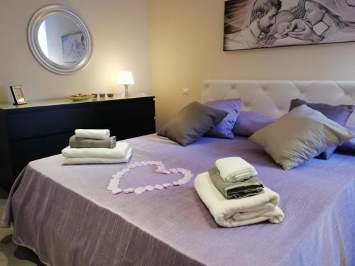 ナポリにあるAnema e Core Apartmentのベッド(タオル付)