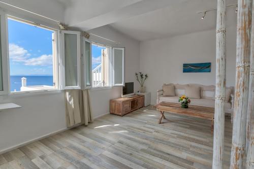 a living room with a couch and a table at With-inn Mykonos Suites in Tourlos