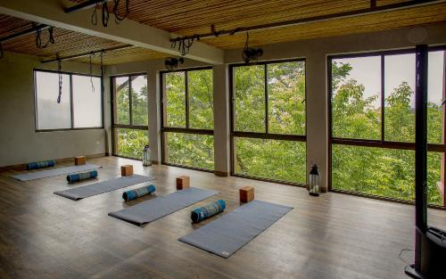 - un groupe de tapis de yoga dans une chambre avec fenêtres dans l'établissement Hotel Boutique Lagarta Lodge, à Nosara
