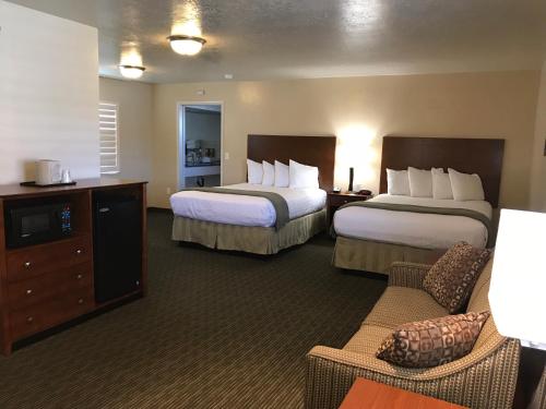 A bed or beds in a room at Dinosaur Inn & Suites