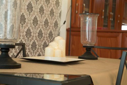 a table with two glass vases and a plate with candles at Luxury City Center Apartment in Kalabaka