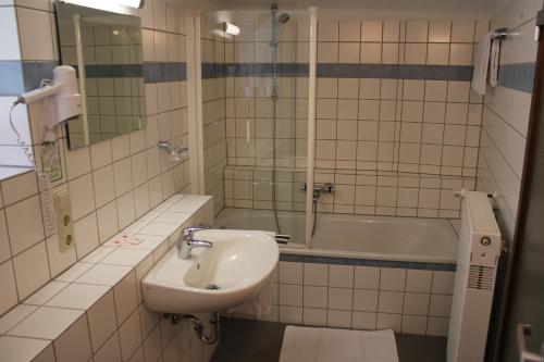 a bathroom with a sink and a bath tub at Landgasthof Schuck in Idar-Oberstein