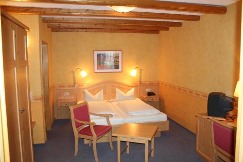 ein Hotelzimmer mit einem Bett, einem Tisch und Stühlen in der Unterkunft Landgasthof Schuck in Idar-Oberstein