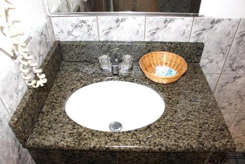 - un comptoir de salle de bains avec un lavabo et un panier dans l'établissement Beacon Motel, à Long Beach