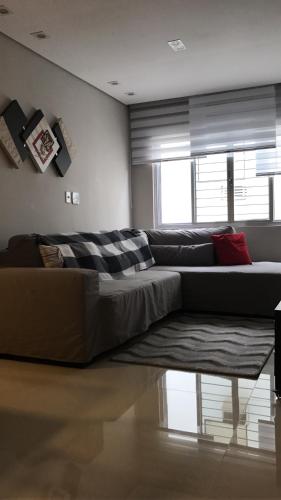a living room with a couch and a window at Apartamento Zapata Guarujá in Guarujá