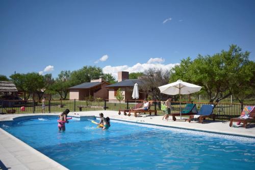 um grupo de crianças a brincar numa piscina em Complejo Sol Serrano em Mina Clavero