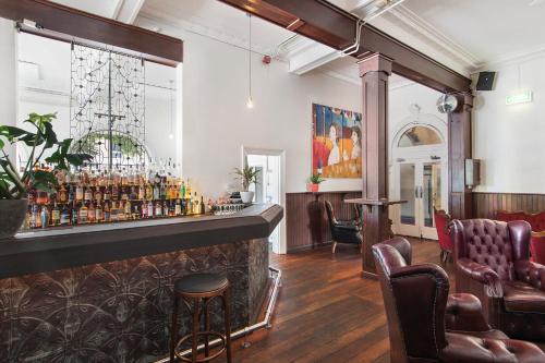 a bar in a room with leather chairs at The Local Hotel in Fremantle