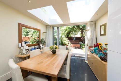 a dining room with a wooden table and a large window at Georgiana's Guesthouse in London