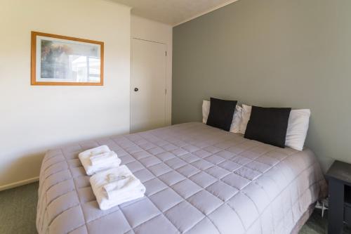 a bedroom with a large bed with towels on it at Motel 22 in Lower Hutt