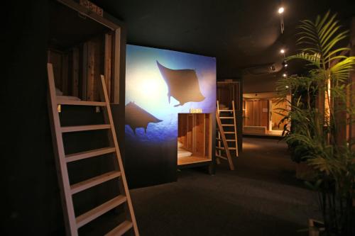 a room with bunk beds and a wall with a painting of a bat at Guest House Chura Cucule Ishigakijima in Ishigaki Island
