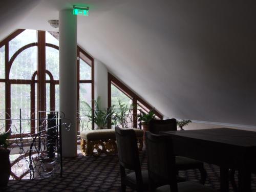 a dining room with a table and chairs and windows at Hotel Royal in Zalău