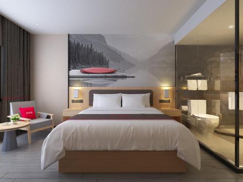 TaixingにあるThank Inn Plus Hotel Jiangsu Taizhou Venice Cityのベッドルーム(大型ベッド1台付)、バスルームが備わります。