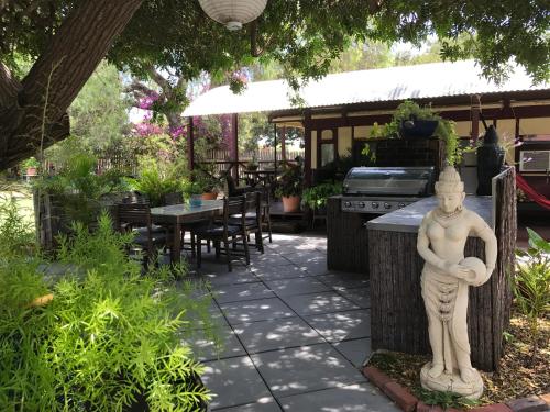 a garden area with tables, chairs, and a fountain at Dongara Breeze Inn in Dongara