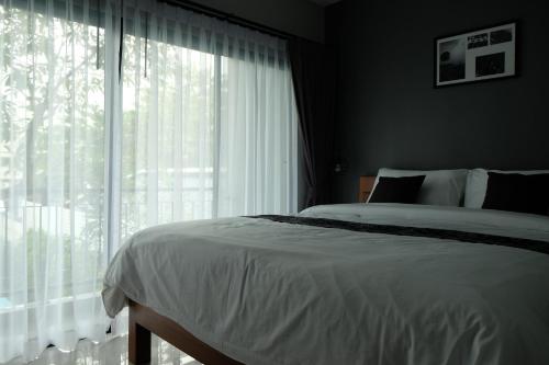 a bedroom with a bed and a large window at The Besavana Phuket - SHA Extra Plus in Phuket Town