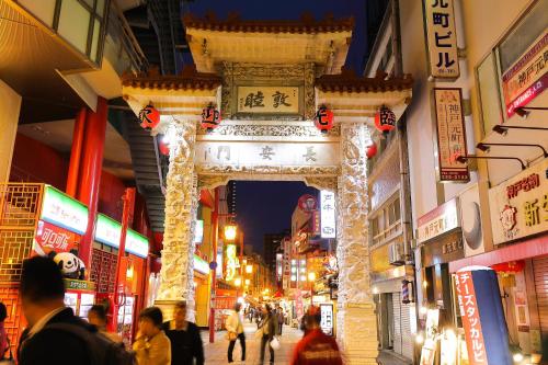 a crowd of people walking through an arch in a shopping mall at Guesthouse Kobe Nadeshikoya in Kobe
