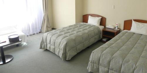 Ένα ή περισσότερα κρεβάτια σε δωμάτιο στο Itoen Hotel Bekkan