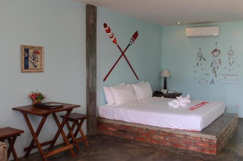 a bedroom with a bed with a clock on the wall at Ocean Front Campgrounds in Ngwesaung