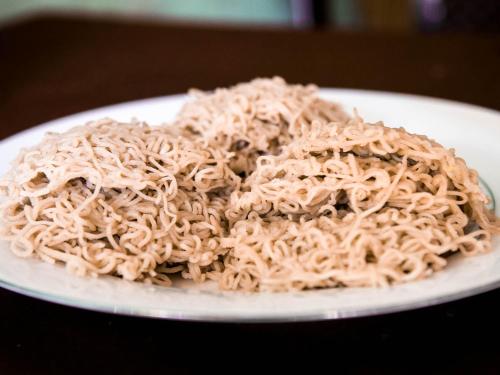 un mucchio di spaghetti su un piatto su un tavolo di Sunstyle Mirissa Guest House a Mirissa