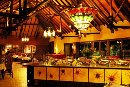 a restaurant with a large kitchen with a chandelier at Muthu Keekorok Lodge, Maasai Mara, Narok in Keekorok