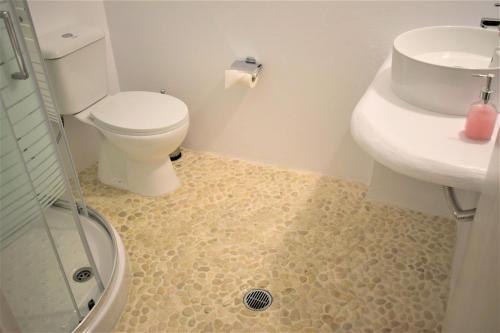 a bathroom with a toilet and a sink and a shower at Blugreen Stegna Suites and Apartments in Archangelos