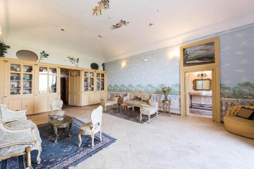 una sala de estar con muebles y una pintura en la pared en Hotel Villa Favorita, en Noto