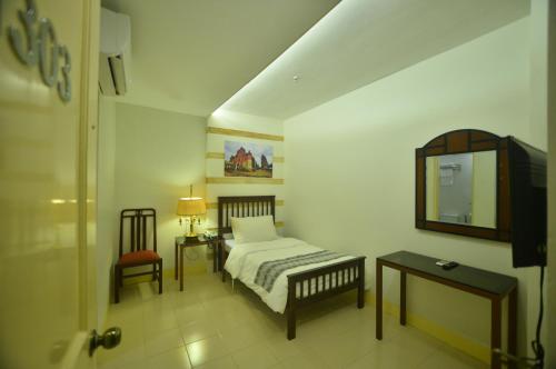 A bed or beds in a room at Metro Vigan Hotel
